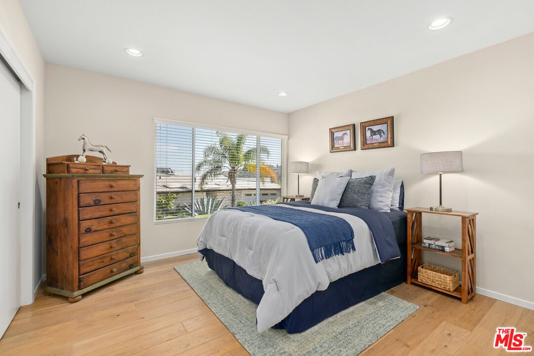 6523 Lakeridge Road Los Angeles, CA 90068 - Photo 21 of 28 a spacious bedroom with a bed a lamp and a large window