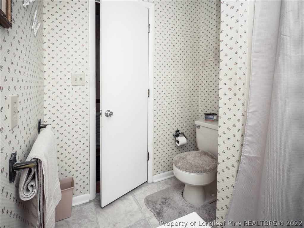 156 Pinewood Road Lumberton, NC 28358 - Photo 32 of 50 a bathroom with a toilet and a shower curtain