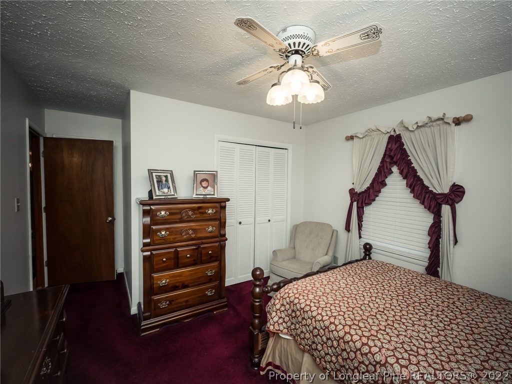 156 Pinewood Road Lumberton, NC 28358 - Photo 34 of 50 a bedroom with a bed and a chandelier