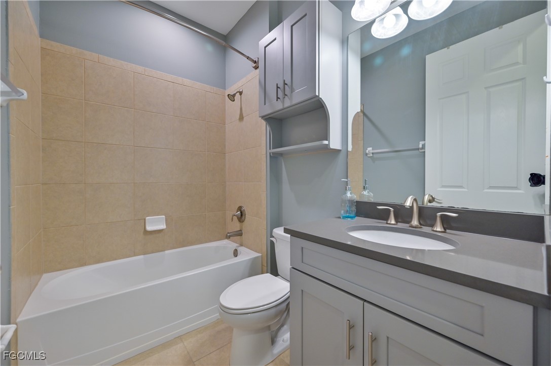 3571 Brittons Court Fort Myers, FL 33916 - Photo 26 of 42 a bathroom with a granite countertop sink a toilet a mirror and bathtub
