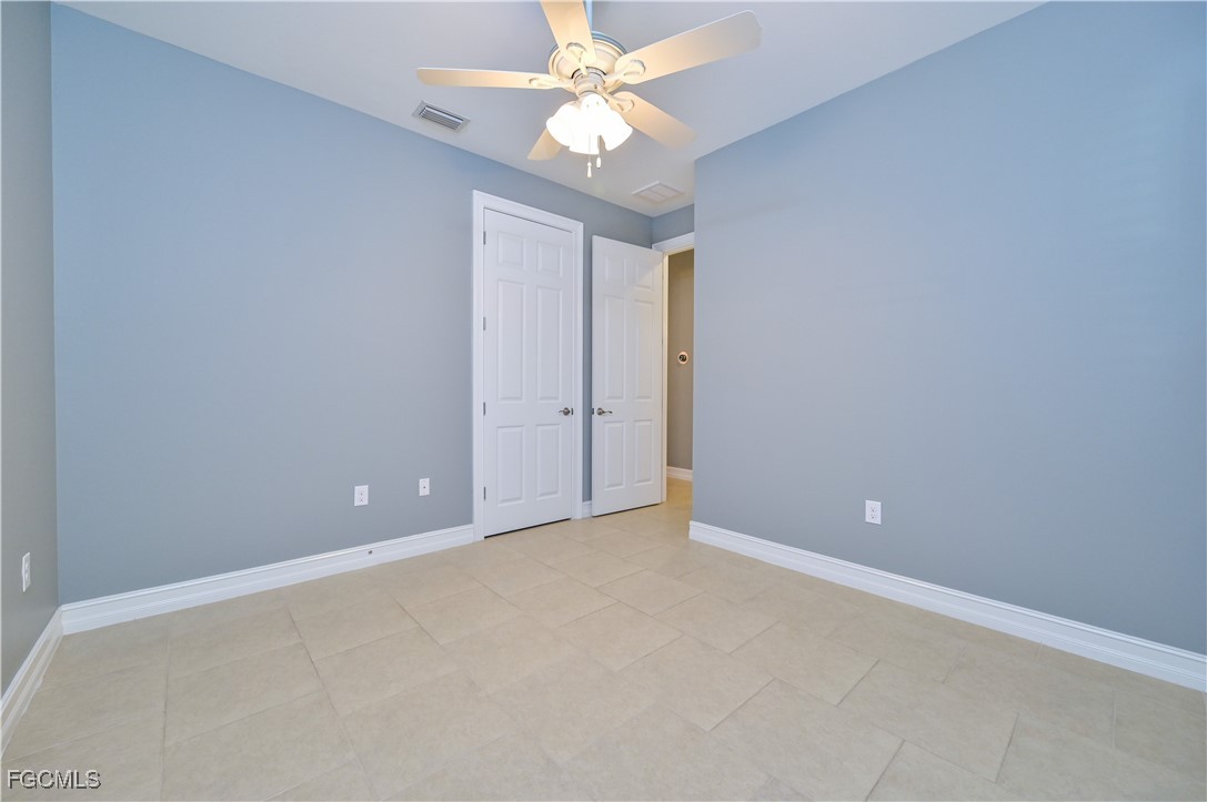 3571 Brittons Court Fort Myers, FL 33916 - Photo 29 of 42 an empty room with a chandelier fan and closet area
