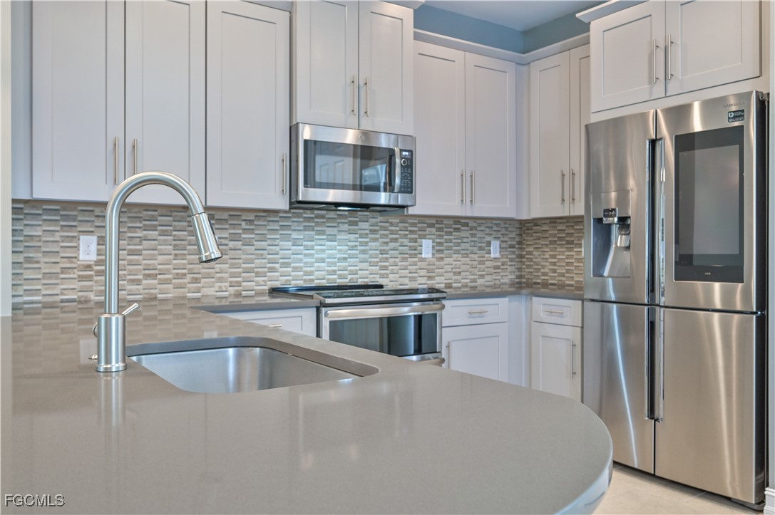 3571 Brittons Court Fort Myers, FL 33916 - Photo 3 of 42 a kitchen with stainless steel appliances granite countertop a refrigerator a stove a sink and white cabinets