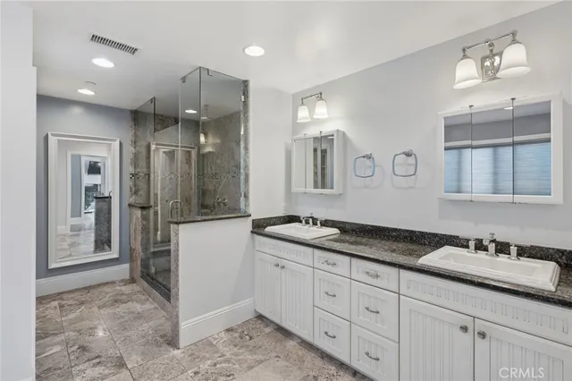 a spacious bathroom with a granite countertop sink mirror and shower