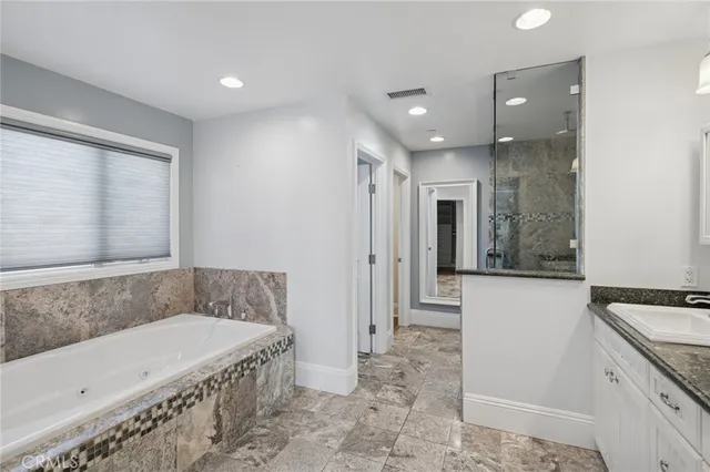 a spacious bathroom with a tub shower and sink