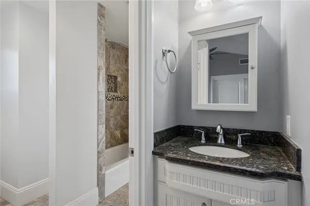 a bathroom with a granite countertop sink and a mirror