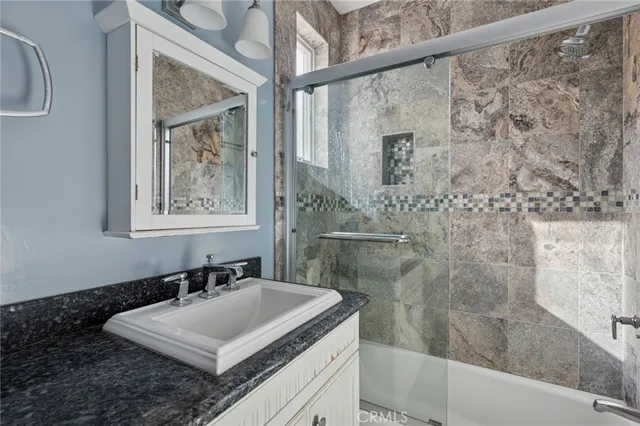 a bathroom with a sink vanity granite and a mirror