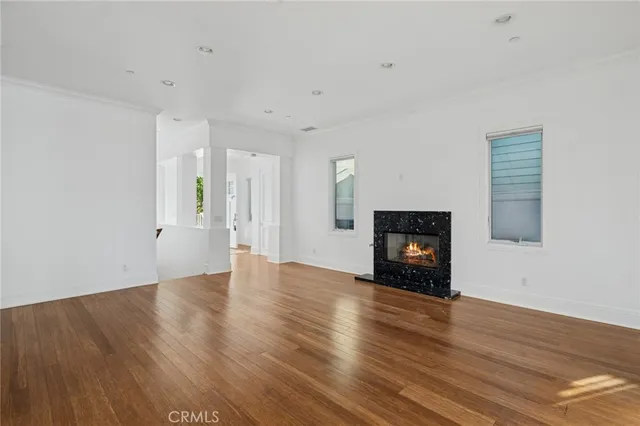 a view of empty room with wooden floor and fireplace