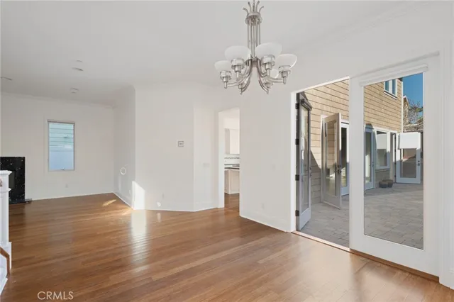 a view of a chandelier with a hardwood floor and a ceiling fan
