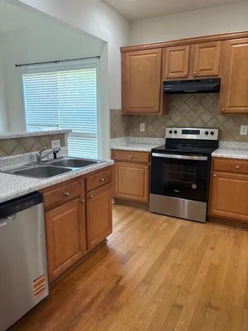 a kitchen with granite countertop a stove a sink and a microwave