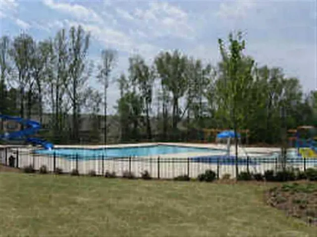 a view of a yard with wooden fence