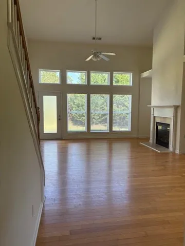 a view of a livingroom with wooden floor and a fireplace