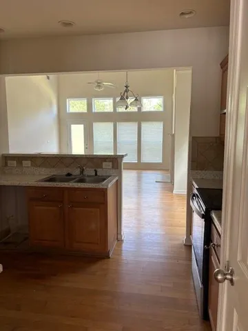 a kitchen with granite countertop a stove and a wooden floors