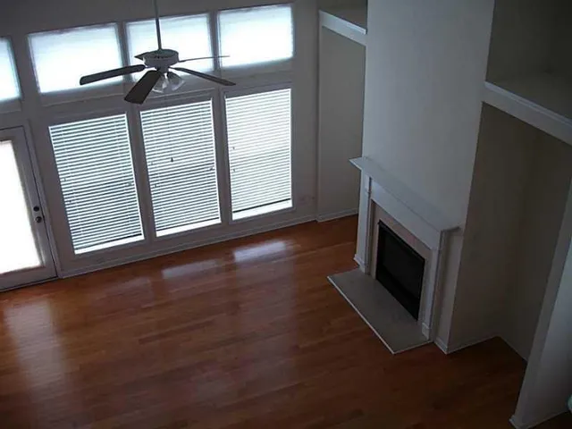 a view of a livingroom with wooden floor and a fireplace