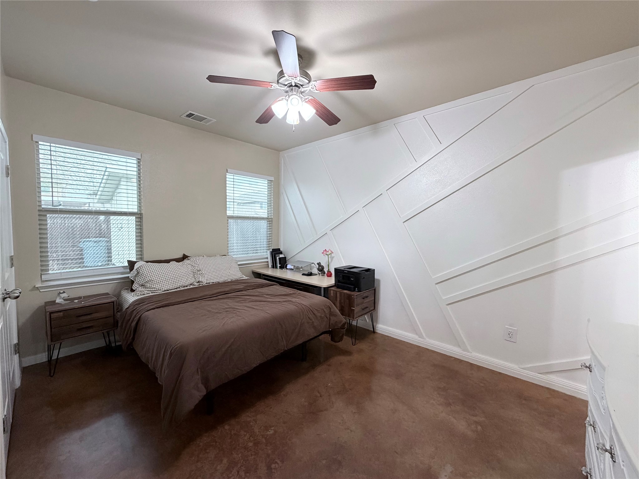 4508 Kind Way, Unit 249 Austin, TX 78725 - Photo 11 of 20 Primary bedroom with decorative wall, a ceiling fan, and concrete flooring.