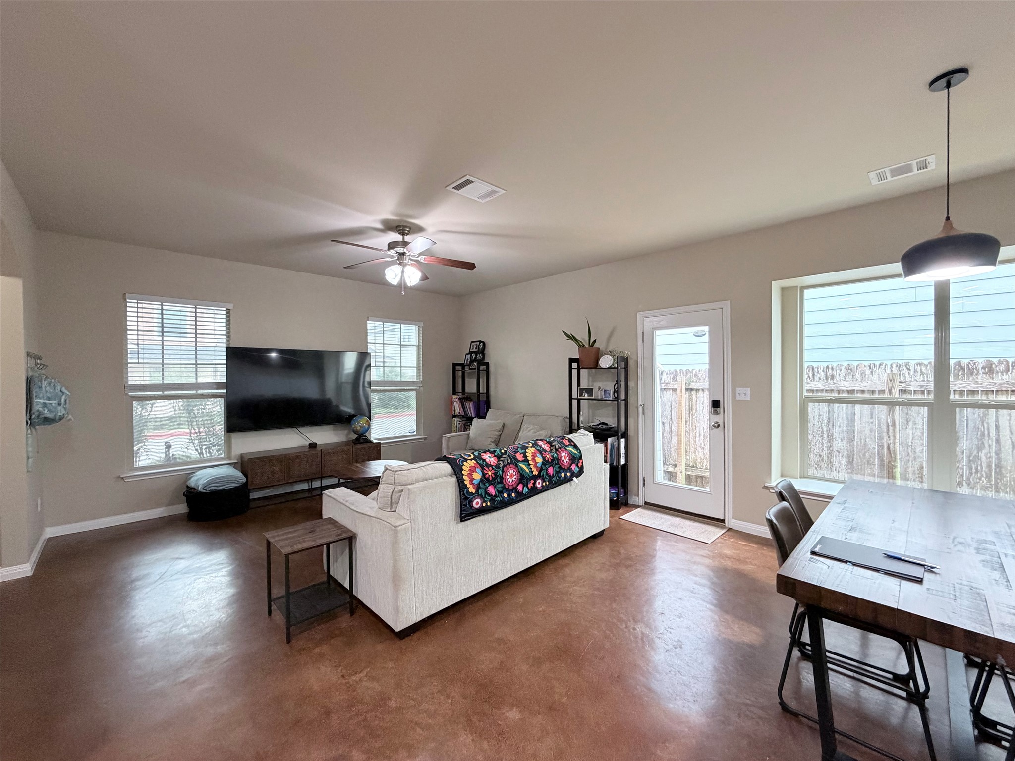 4508 Kind Way, Unit 249 Austin, TX 78725 - Photo 4 of 20 Living room featuring a ceiling fan and concrete floors.