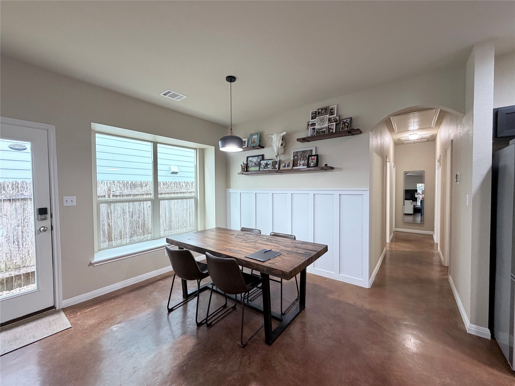 4508 Kind Way, Unit 249 Austin, TX 78725 - Photo 5 of 20 Dining room with finished concrete floors and a decorative wall.