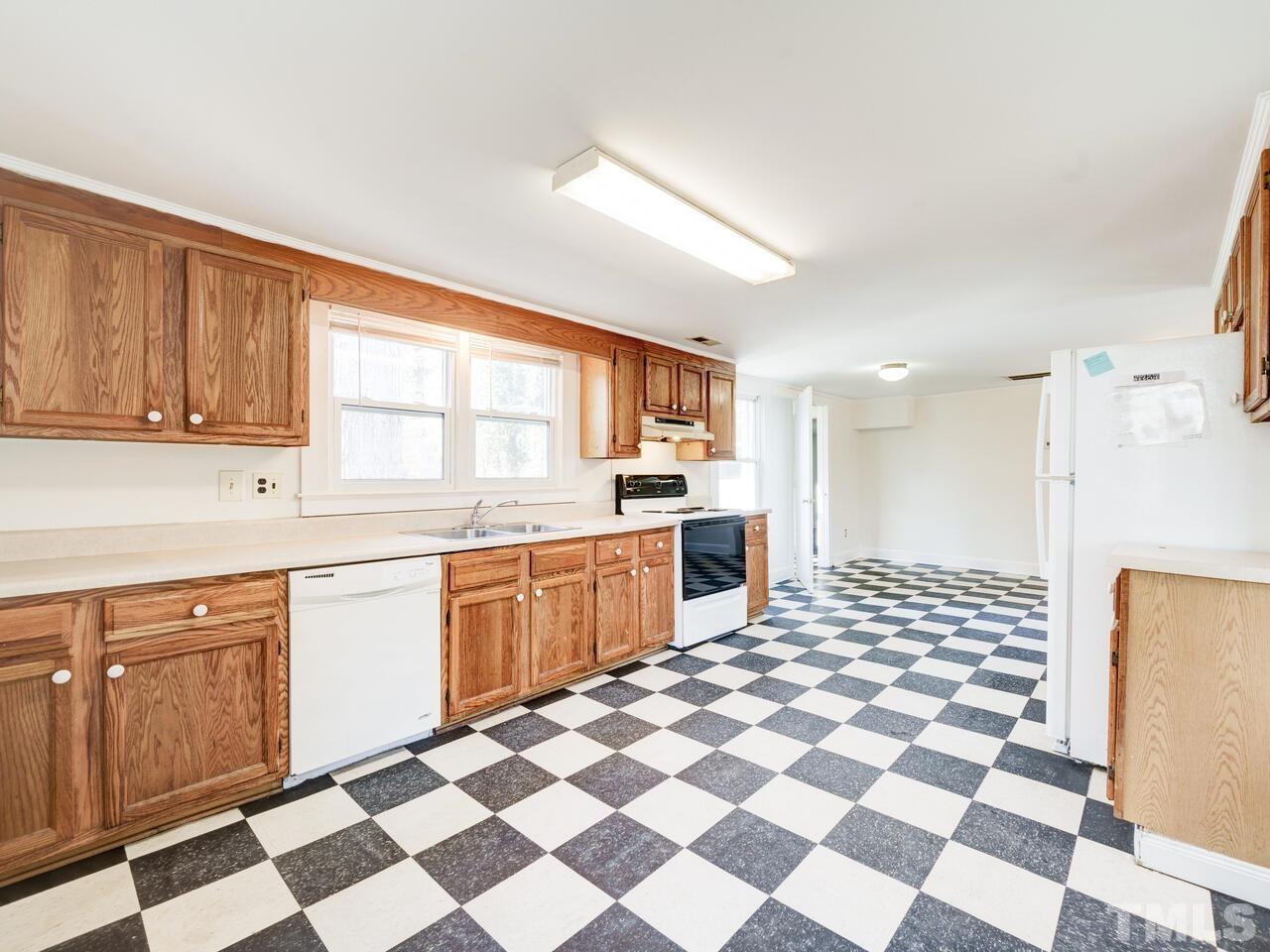 269 Hesters Store Road Roxboro, NC 27574 - Photo 13 of 30 a kitchen with a checkered floor and white cabinets