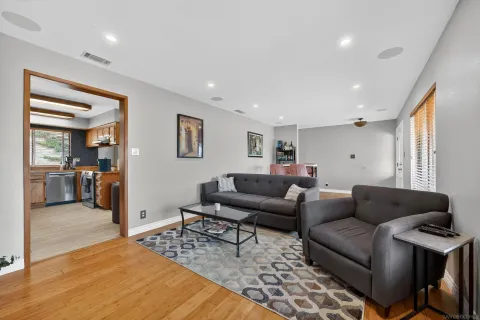 a living room with furniture and a wooden floor