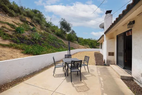 a view of a patio with a table and chairs and potted plants