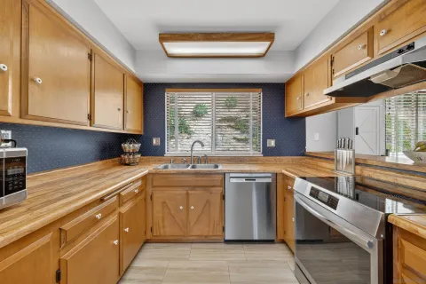 a kitchen with stainless steel appliances granite countertop a sink and a stove