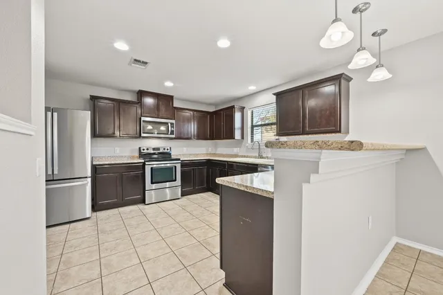 a kitchen with kitchen island a counter top space appliances and a counter top space