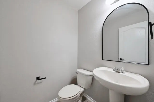 a bathroom with a sink a toilet and mirror