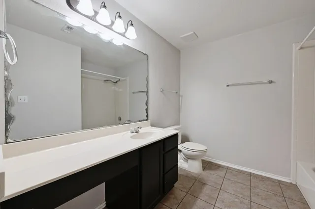 a bathroom with a double vanity sink mirror and toilet