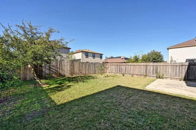 a view of a backyard with wooden fence