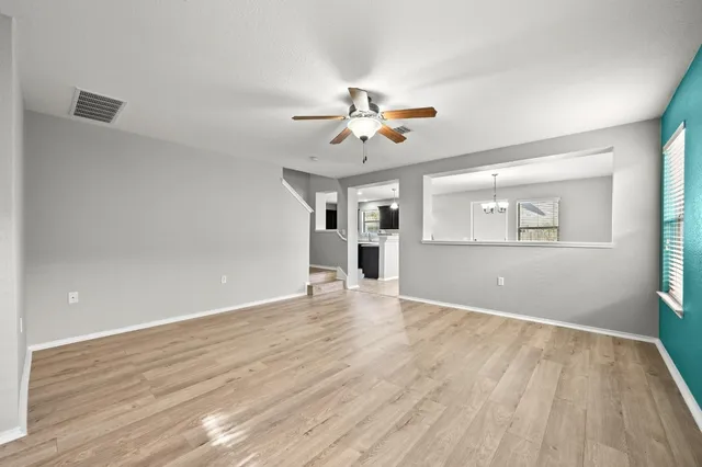 a view of an empty room with a window and wooden floor