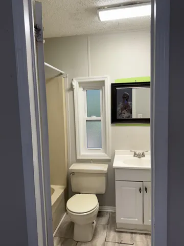 a bathroom with a toilet sink and mirror