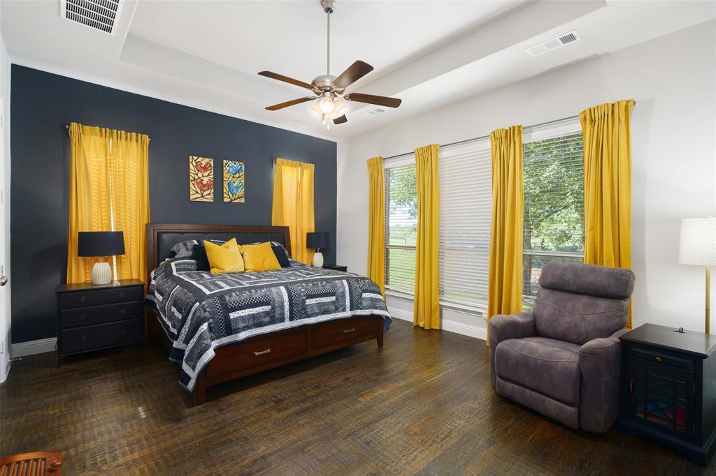 191 Daniel Drive Van Alstyne, TX 75495 - Photo 10 of 30 a spacious bedroom with a bed and wooden floor