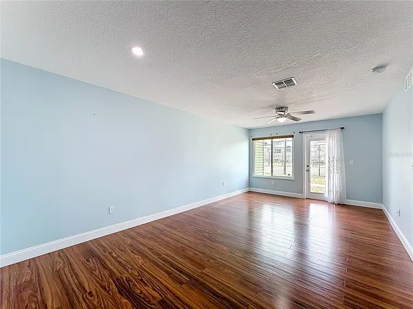a view of a room with wooden floor and white walls