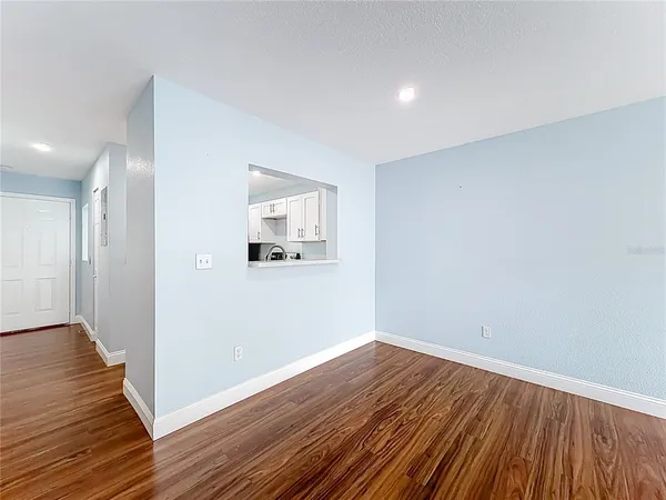a view of a room with wooden floor and white walls