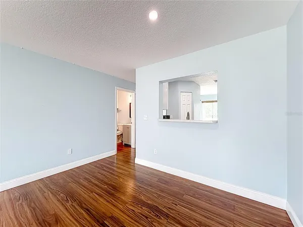 an empty room with wooden floor cabinet and windows