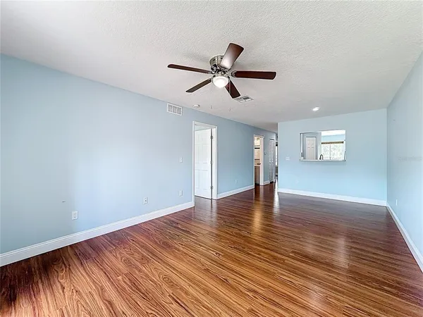 an empty room with wooden floor and windows