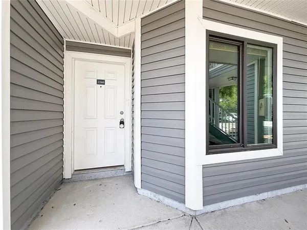 a view of an empty room with closet and a window