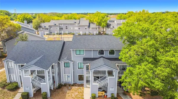 an aerial view of residential houses with outdoor space and ocean view