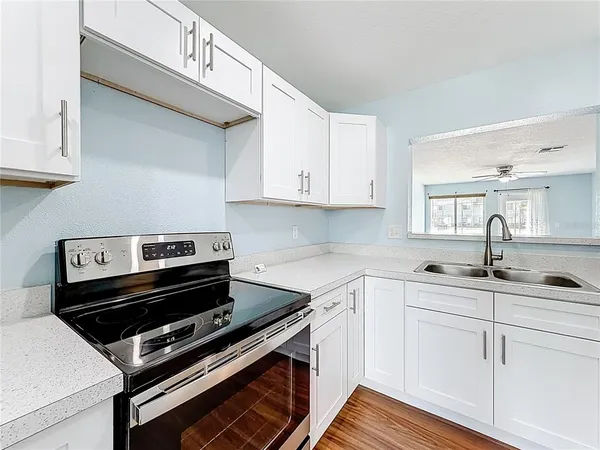 a kitchen with sink a microwave and cabinets