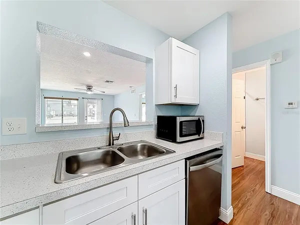 a kitchen with stainless steel appliances granite countertop a refrigerator a stove top oven a sink and dishwasher