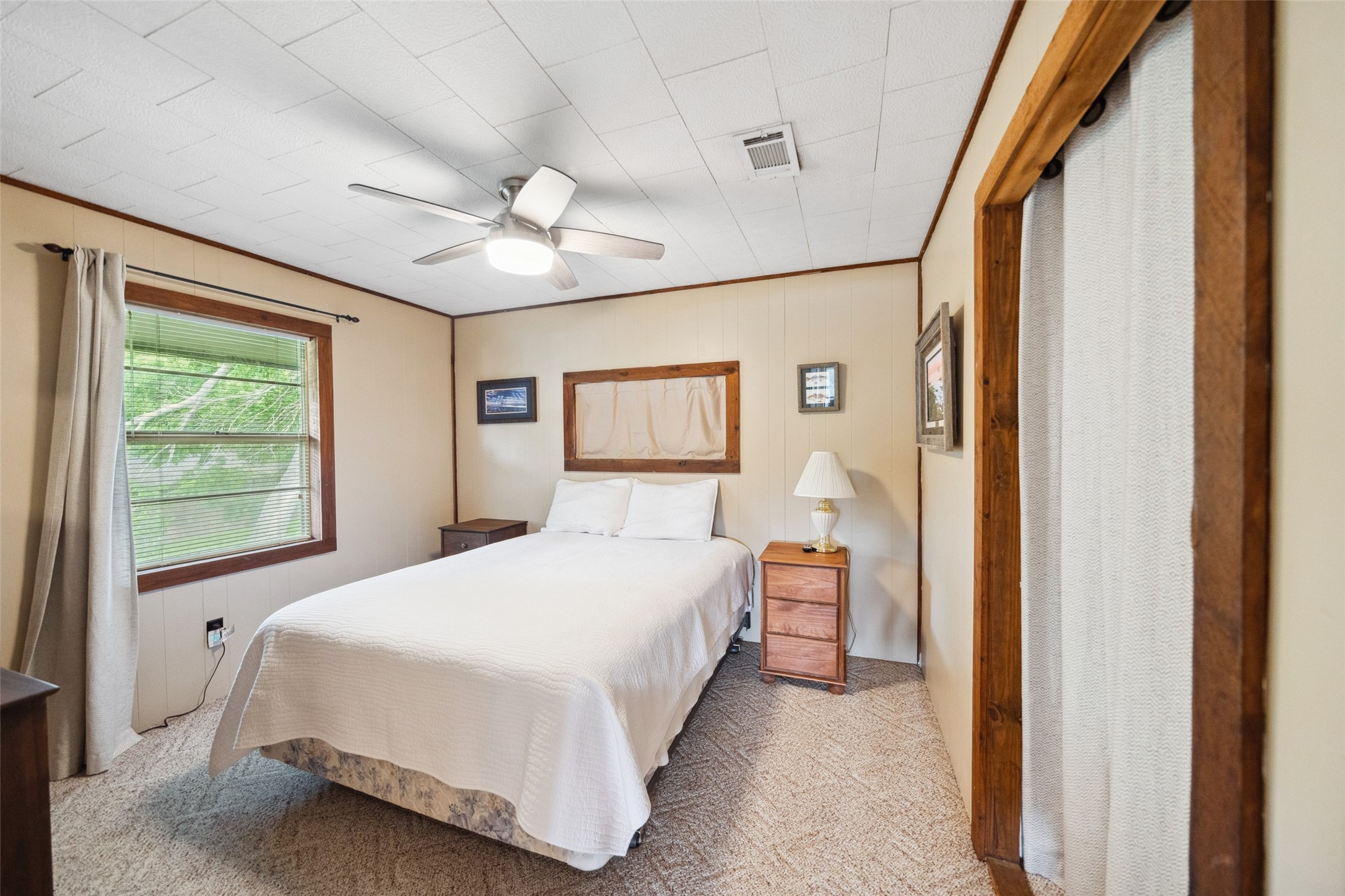 215 Selkirk Road Bay City, TX 77414 - Photo 18 of 36 a bedroom with a large bed and a chandelier