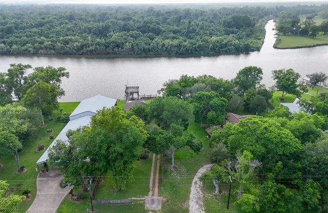 an aerial view of a house with a yard and lake view