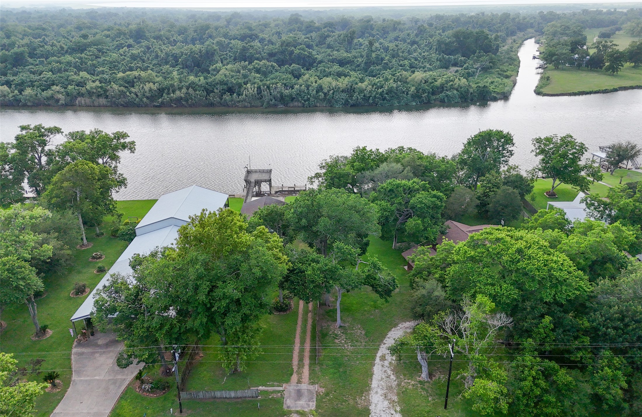 215 Selkirk Road Bay City, TX 77414 - Photo 21 of 36 an aerial view of green landscape with trees houses and lake view