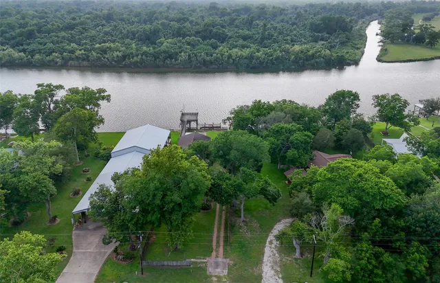 an aerial view of a house with a yard and lake view