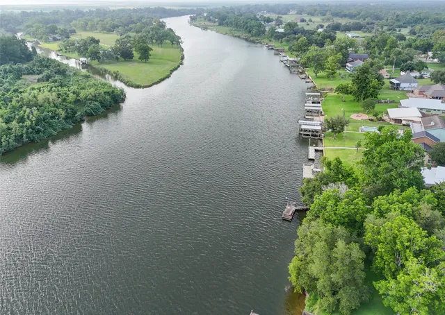 an aerial view of a house with a yard and lake view
