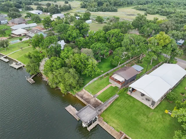 an aerial view of a house with a yard and lake view
