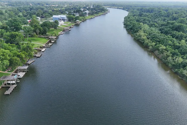 an aerial view of a house with swimming pool patio and lake view