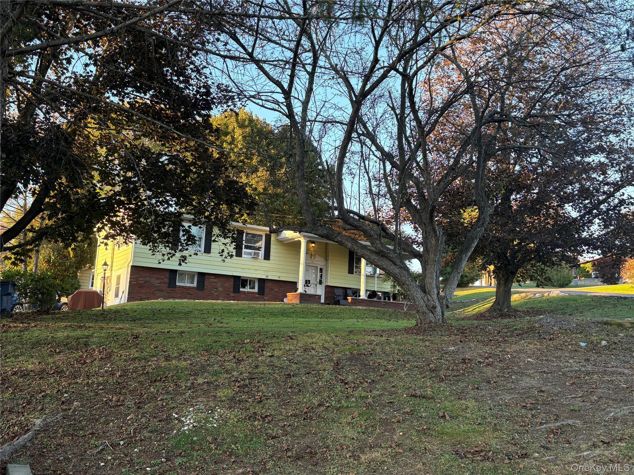 View of front of property with brick siding and a front lawn