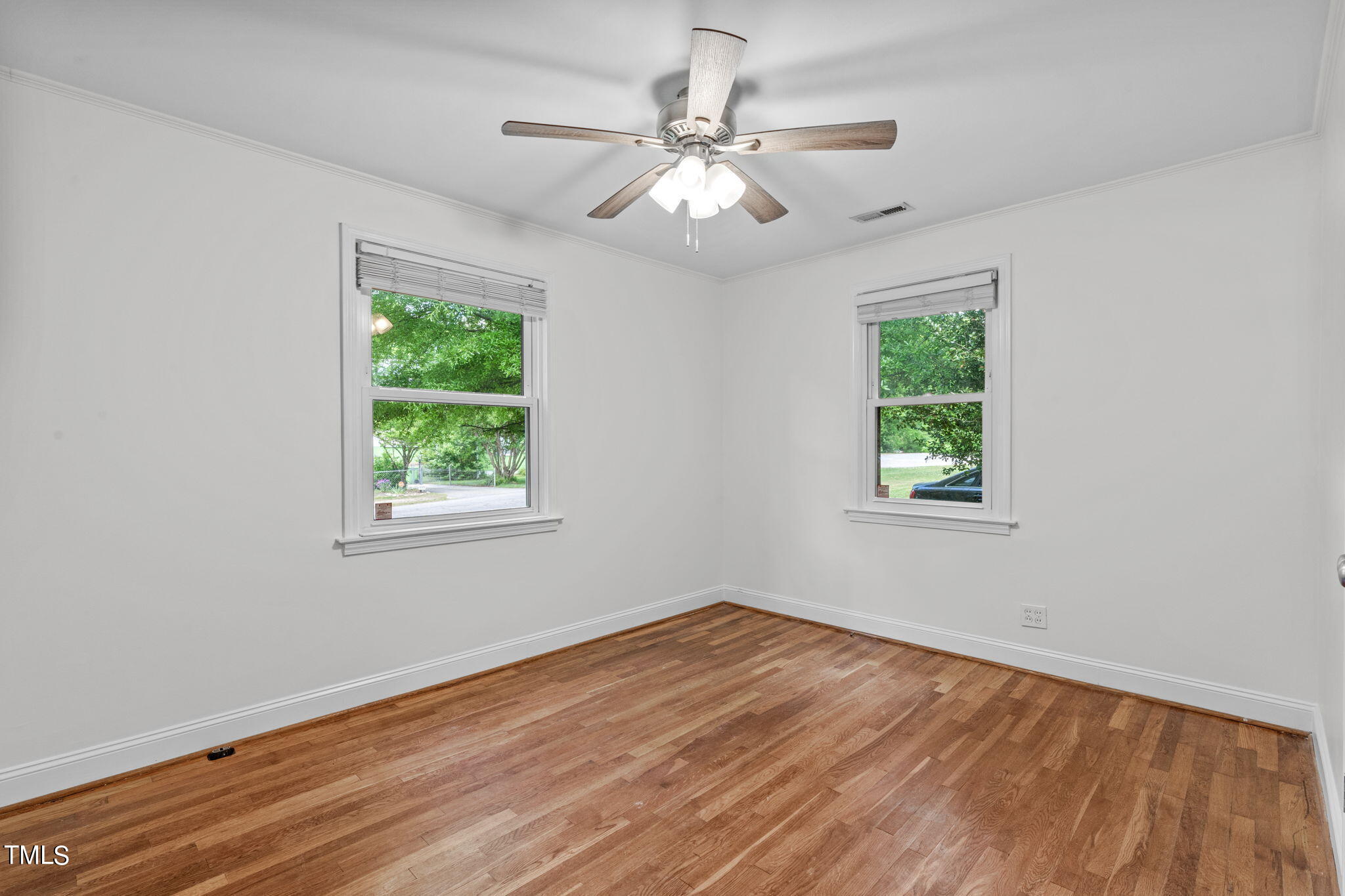 816 Colleton Road Raleigh, NC 27610 - Photo 28 of 49 a view of an empty room with wooden floor and a window