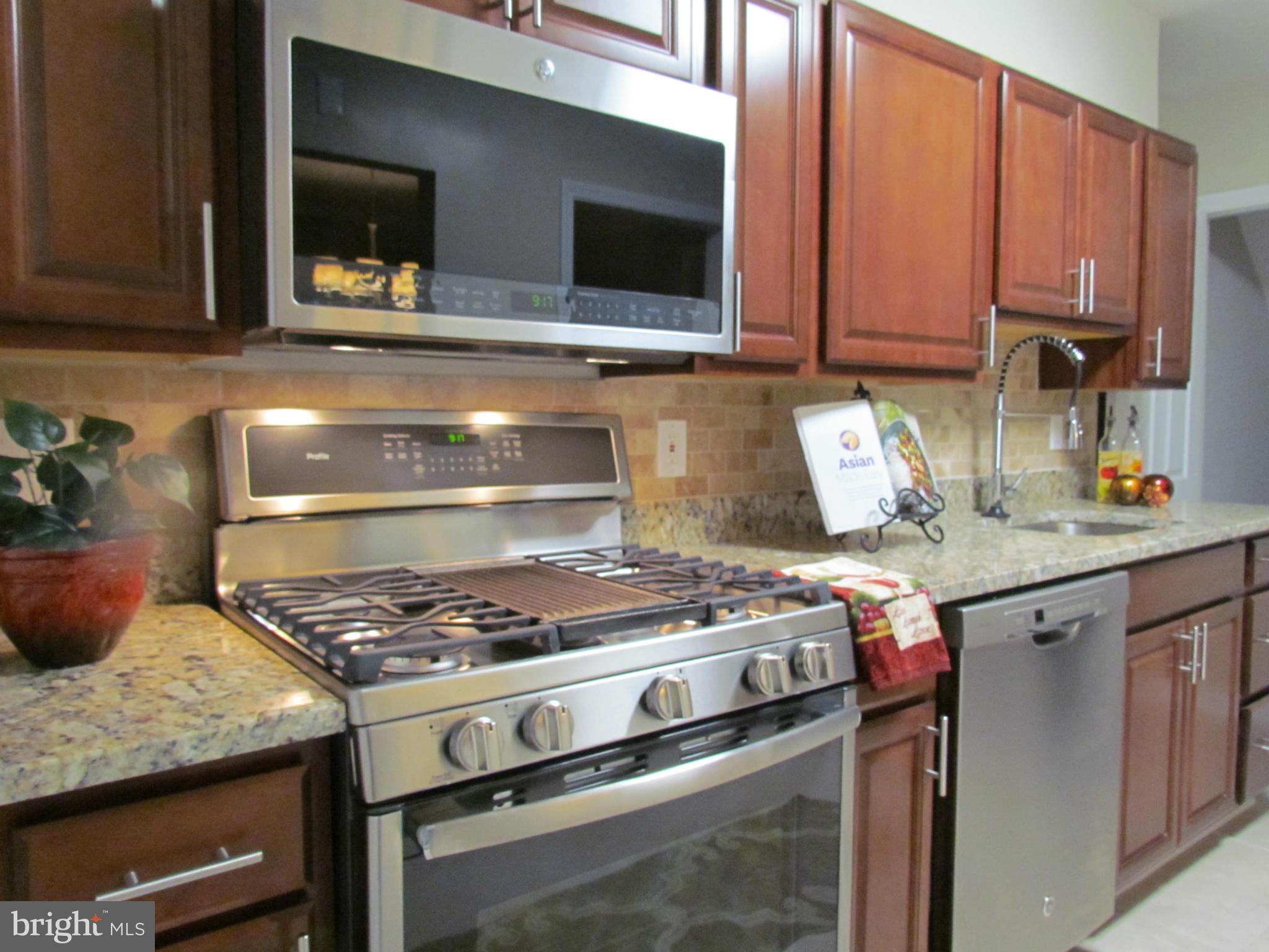 1634 Ingram Road Baltimore, MD 21239 - Photo 1 of 21 a kitchen with stainless steel appliances granite countertop a stove and a microwave