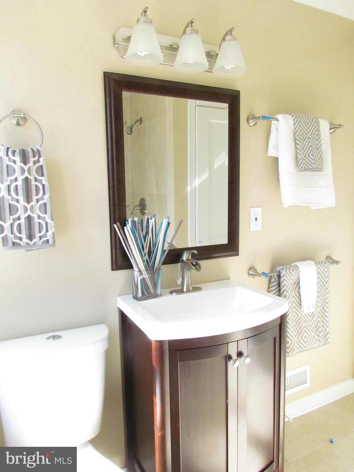 1634 Ingram Road Baltimore, MD 21239 - Photo 14 of 21 a bathroom with a sink a mirror and a bathtub